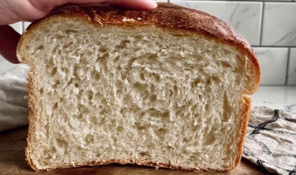 Sliced easy sourdough discard sandwich bread on cutting board showing soft fluffy texture