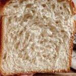 Sliced easy sourdough discard sandwich bread on cutting board showing soft fluffy texture