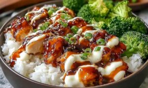 Sticky Chicken Rice Bowls - An Incredible Ultimate Recipe for Every Occasion Sticky chicken rice bowls with glazed chicken thighs, jasmine rice, broccoli, carrots, and sesame seeds in a white bowl