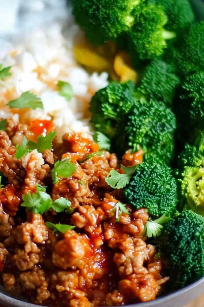 Sweet and spicy ground turkey and broccoli bowls served over brown rice with sesame seeds and green onions