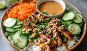 Thai Peanut Chicken Buddha Bowl with quinoa, shredded cabbage, carrots, edamame, and peanut sauce