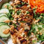 Thai Peanut Chicken Buddha Bowl with quinoa, shredded cabbage, carrots, edamame, and peanut sauce