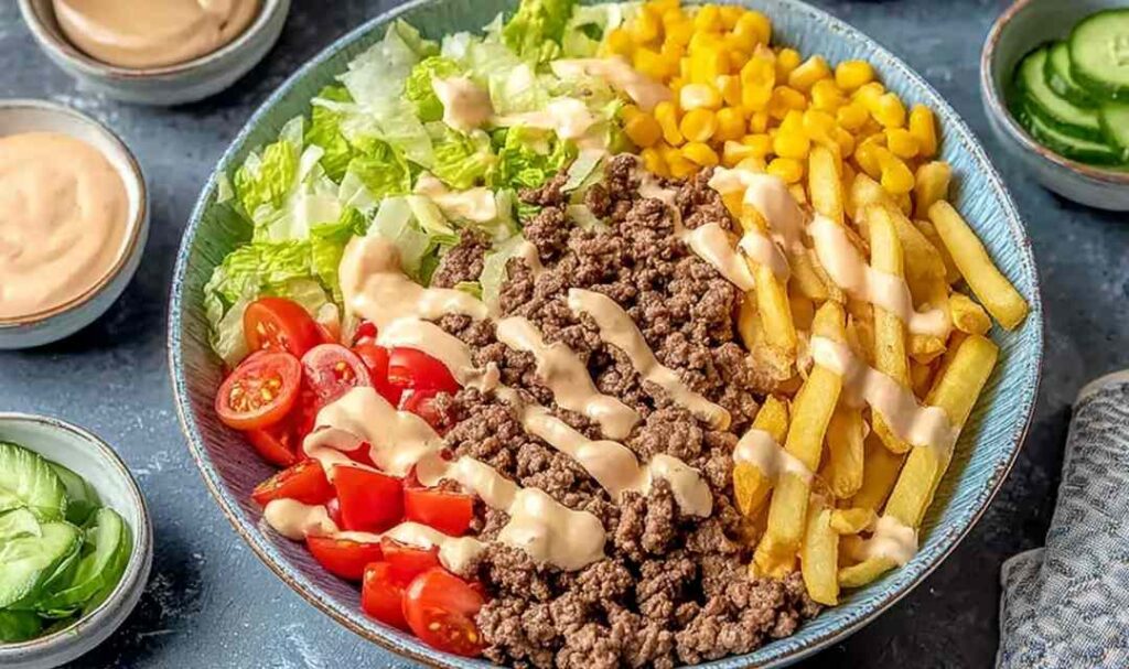 Big Mac Bowls with seasoned ground beef, shredded lettuce, cherry tomatoes, pickles, cheddar cheese, and creamy special sauce
