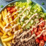 Big Mac Bowls with seasoned ground beef, shredded lettuce, cherry tomatoes, pickles, cheddar cheese, and creamy special sauce