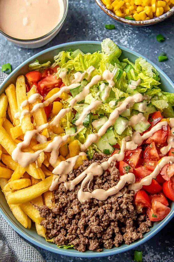 Big Mac Bowls with seasoned ground beef, shredded lettuce, cherry tomatoes, pickles, cheddar cheese, and creamy special sauce