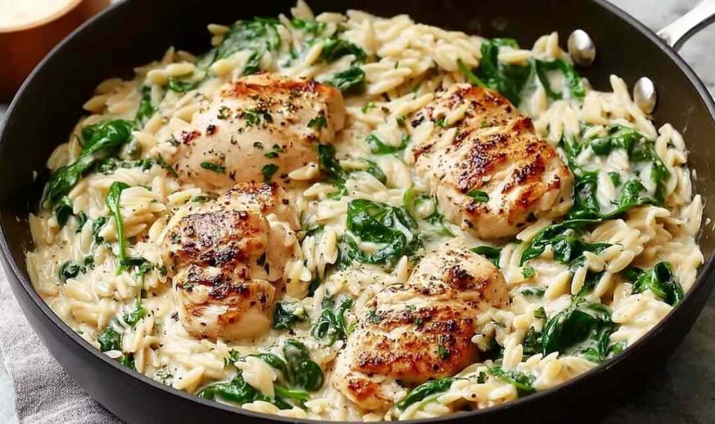 Boursin orzo with chicken in a skillet topped with fresh basil and Parmesan