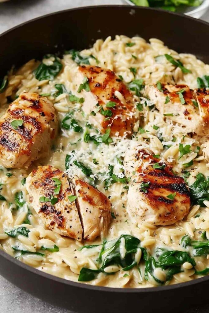 Boursin orzo with chicken in a skillet topped with fresh basil and Parmesan