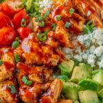Buffalo Chicken Protein Bowl with shredded buffalo chicken, quinoa, cherry tomatoes, avocado, and ranch dressing