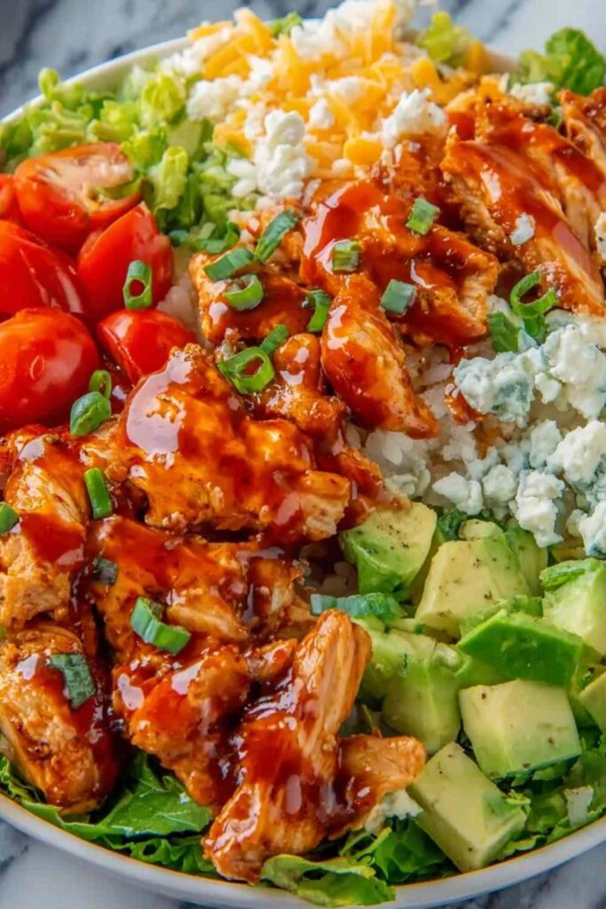 Buffalo Chicken Protein Bowl with shredded buffalo chicken, quinoa, cherry tomatoes, avocado, and ranch dressing