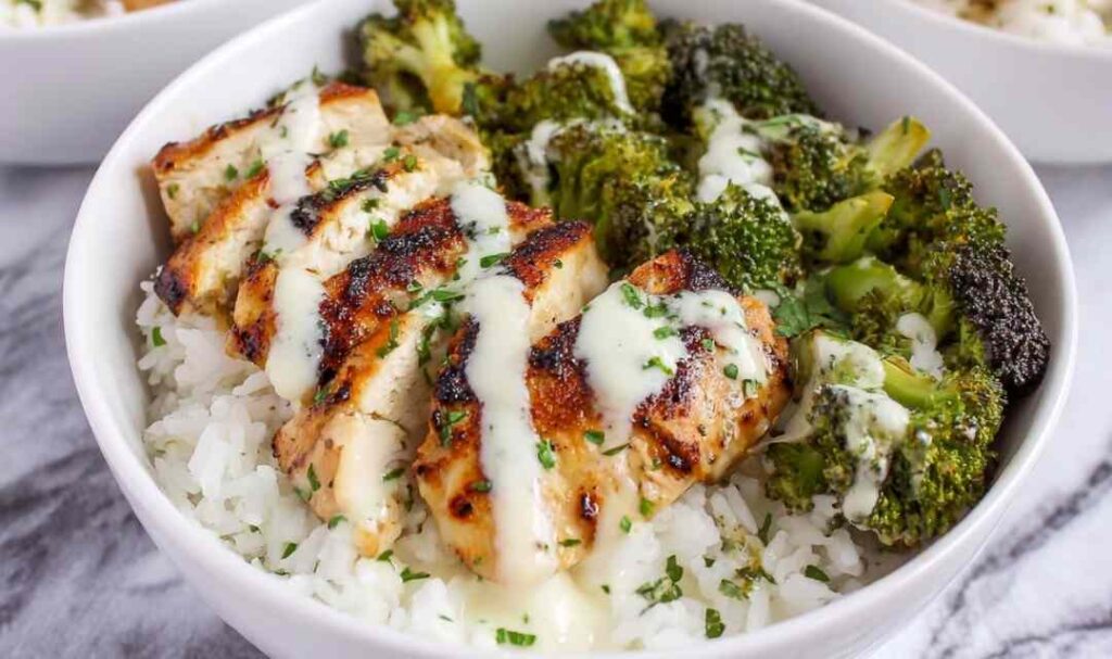 Chicken and Broccoli Bowls with Creamy Garlic Sauce 5 Chicken and broccoli bowls with creamy garlic sauce served over white rice with fresh parsley garnish