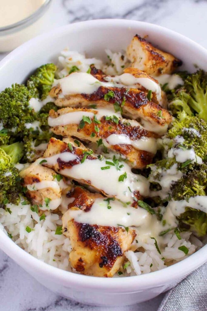 Chicken and Broccoli Bowls with Creamy Garlic Sauce 6 Chicken and broccoli bowls with creamy garlic sauce served over white rice with fresh parsley garnish