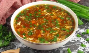 Bowl of authentic Chinese hot and sour soup with egg ribbons, tofu, and mushrooms