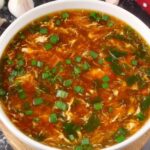 Bowl of authentic Chinese hot and sour soup with egg ribbons, tofu, and mushrooms