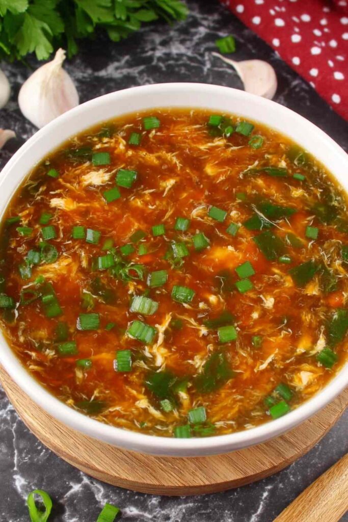 Bowl of authentic Chinese hot and sour soup with egg ribbons, tofu, and mushrooms