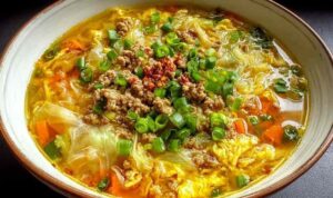One pot egg roll soup with ground beef, cabbage, and green onions in a white bowl