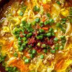 One pot egg roll soup with ground beef, cabbage, and green onions in a white bowl