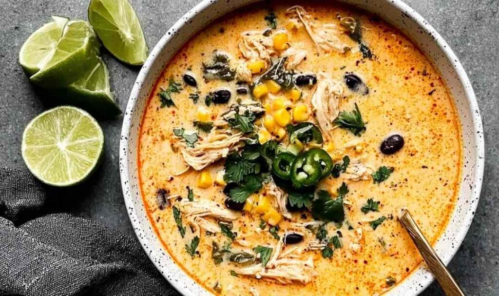 Chicken Poblano Soup 5 Creamy chicken poblano soup in a bowl garnished with fresh cilantro and lime wedges