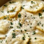Creamy lemon garlic sauce for ravioli in a pan with Parmesan and fresh parsley