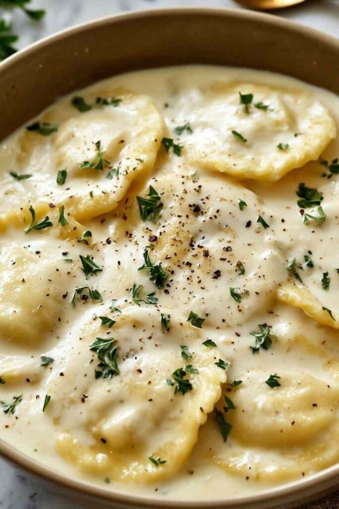 Creamy lemon garlic sauce for ravioli in a pan with Parmesan and fresh parsley