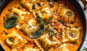 Easy Tuscan ravioli soup served in a white bowl topped with Parmesan cheese and fresh spinach