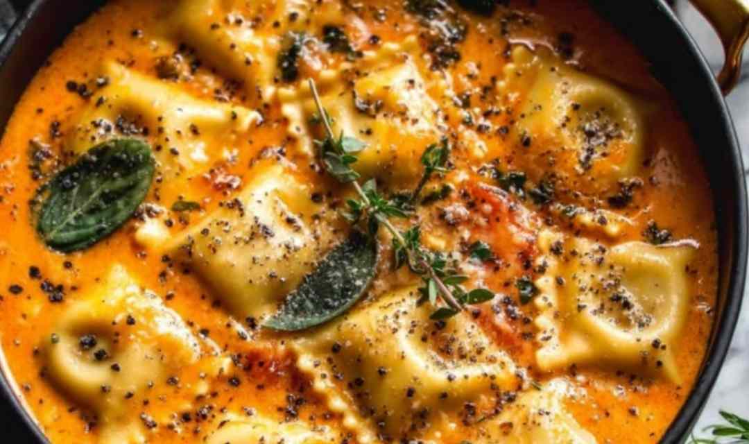 Easy Tuscan ravioli soup served in a white bowl topped with Parmesan cheese and fresh spinach