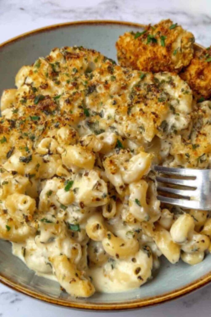 Creamy French onion soup pasta in a skillet topped with fresh parsley and melted Gruyere cheese
