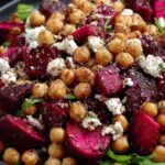 Chickpea beet and feta salad in a large white bowl with fresh mint and parsley