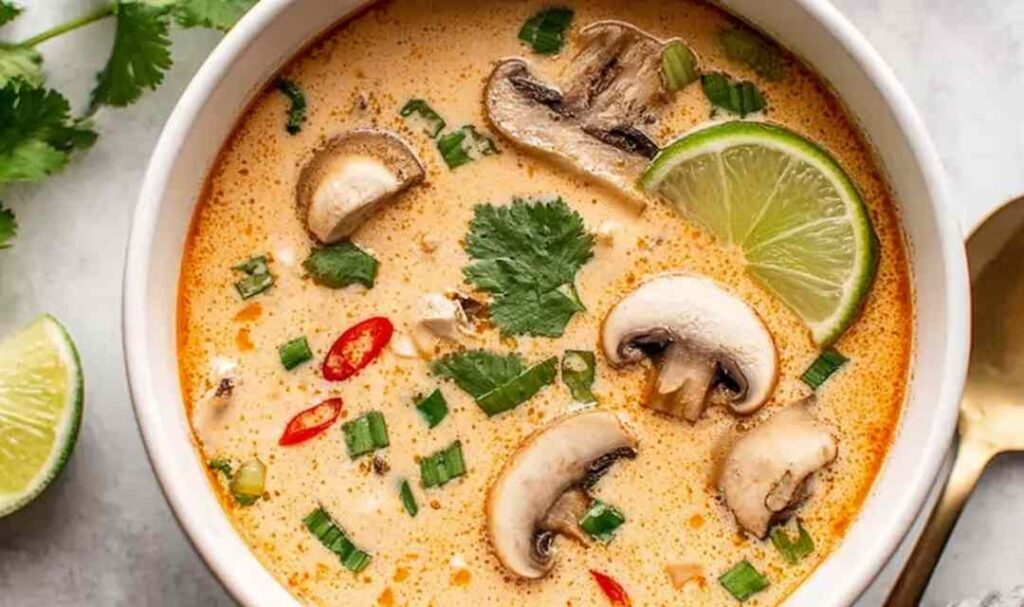 Grilled Greek chicken tenders on a white plate garnished with fresh dill and lemon slices