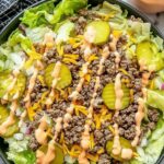 High-protein cheeseburger bowl with seasoned ground beef, cheddar cheese, pickles, tomatoes, and creamy cottage cheese sauce