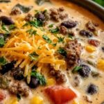 Creamy cowboy soup in a rustic bowl topped with crispy bacon and fresh parsley