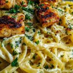 Creamy Cajun chicken linguine in a skillet with melted mozzarella and fresh parsley garnish