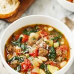 Bowl of Italian vegetable soup with cannellini beans, ditalini pasta, fresh spinach, and grated Parmesan cheese