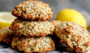 Lemon chia breakfast cookies stacked on a white plate with fresh lemon slices and zest