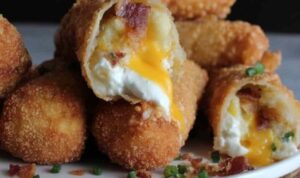 Crispy loaded mashed potato egg rolls on a wire rack garnished with sliced green onions
