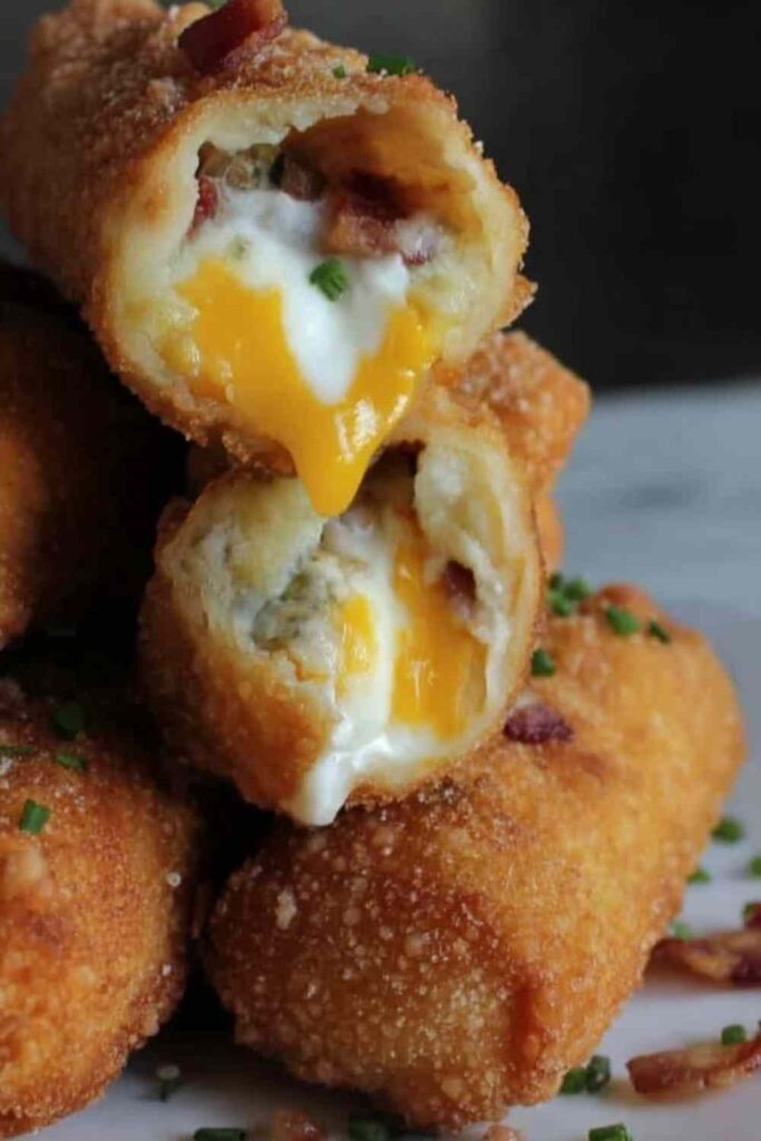 Crispy loaded mashed potato egg rolls on a wire rack garnished with sliced green onions