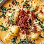 Bowl of Marry Me Soup with shredded chicken in creamy tomato broth topped with fresh basil and Parmesan