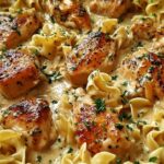 One pan creamy garlic butter chicken with egg noodles in a skillet garnished with fresh parsley