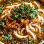 A bowl of Persian Noodle Soup (Ash-e Reshteh) topped with kashk, mint oil, and caramelized onions