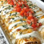 Queso chicken enchiladas baked in a dish with creamy homemade queso sauce and melted cheese