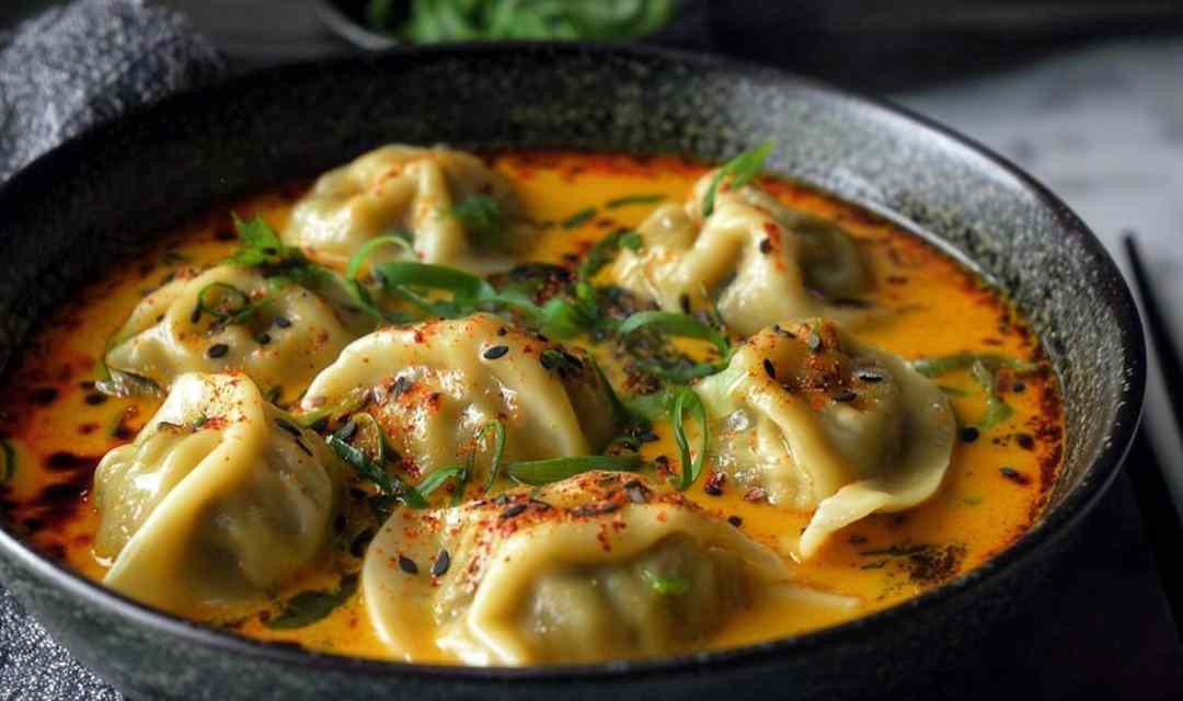 Quick coconut curry soup with dumplings in a white bowl garnished with fresh cilantro and lime wedge
