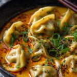 Quick coconut curry soup with dumplings in a white bowl garnished with fresh cilantro and lime wedge