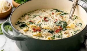 Quick white lasagna soup in a white bowl with melted mozzarella and fresh basil garnish