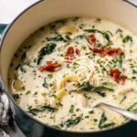 Quick white lasagna soup in a white bowl with melted mozzarella and fresh basil garnish