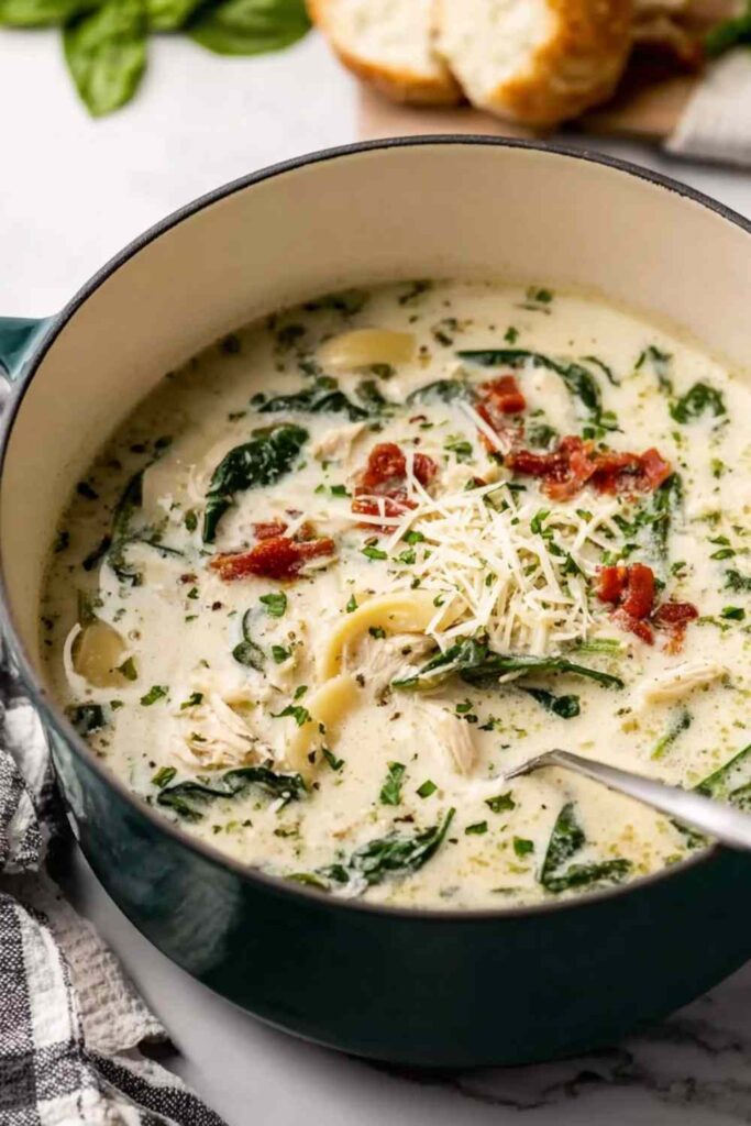 Quick white lasagna soup in a white bowl with melted mozzarella and fresh basil garnish