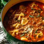 Simple lasagna soup with Italian sausage and ricotta topping in a white bowl