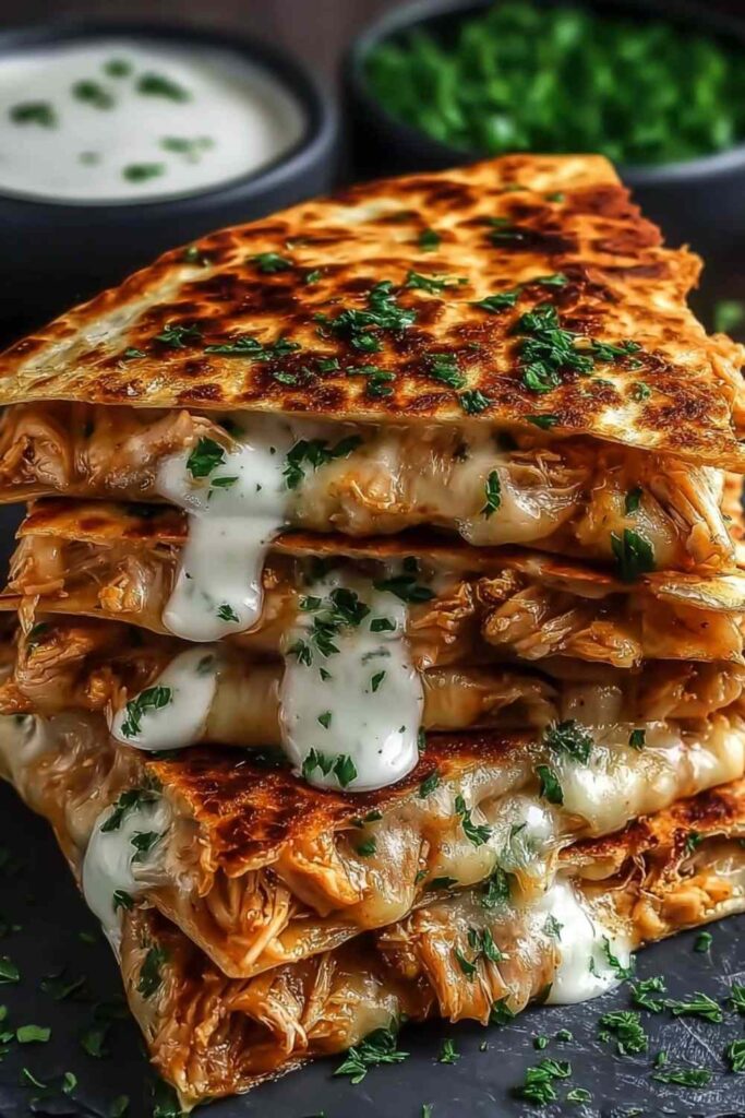 Cheesy hot honey chicken quesadillas sliced into wedges with spicy jalapeño cream sauce dipping bowl
