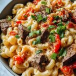 Steak Pepper Jack Queso Mac and Cheese in a baking dish with golden breadcrumb topping