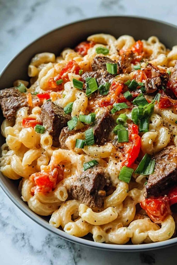 Steak Pepper Jack Queso Mac and Cheese in a baking dish with golden breadcrumb topping