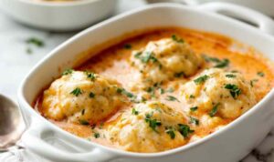 Tomato soup with cheddar bay dumplings in a Dutch oven with fluffy golden dumplings on top