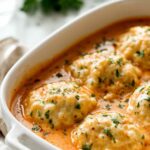 Tomato soup with cheddar bay dumplings in a Dutch oven with fluffy golden dumplings on top